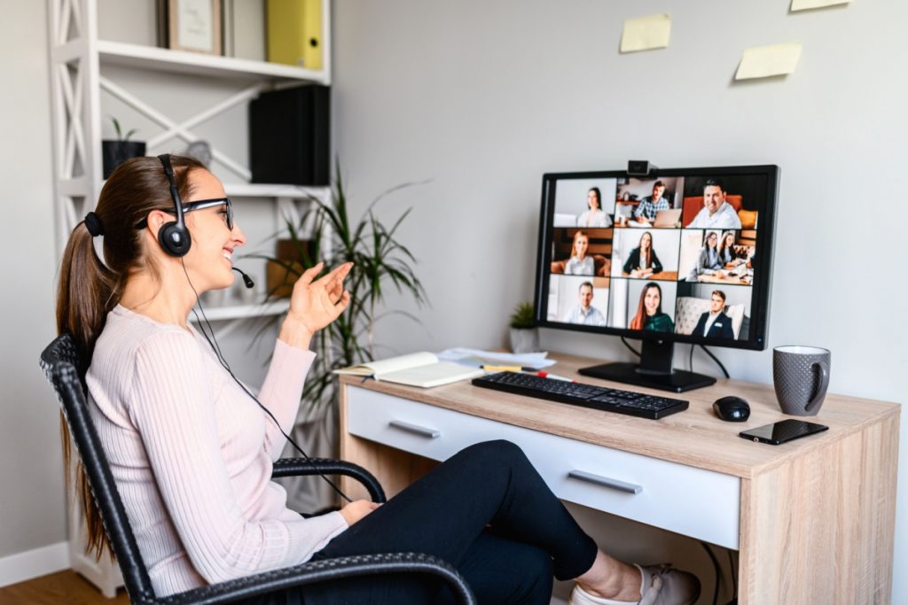 Woman on headset talking in conference call on computer.