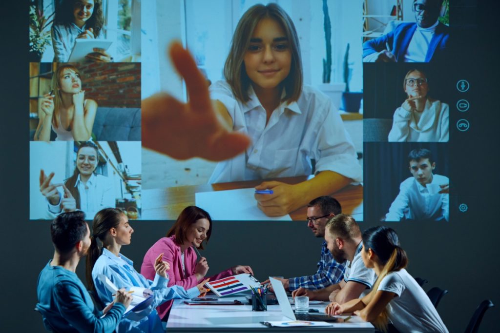 Employees in a conference room with a screen